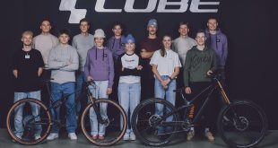 CUBE sponsored MTB riders together as a squad. Stood with bike in centre and CUBE brand above heads behind them.