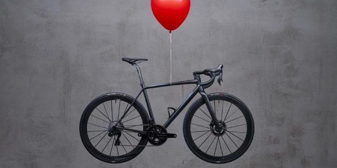 Officine Mattio ultra light bike hovering in mid air, with red ballon tided around the middle of the top tube
